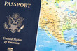 © Dominique James - The foil-stamped dark blue front cover of an American passport set on a world map background.