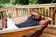 © Inti St. Clair - Man relaxing in hammock on deck of home