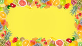 Fototapeta Kuchnia - Creative photo of many different exotic tropical bright fruits frame on a summer yellow color background. View from above. Bright summer fruit pattern with copy space.