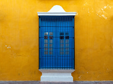 A Blue Window On A Yellow Wall, A Colorful Facade In The Historic City Center Of Campeche, Yucatan Peninsula, Mexico.
