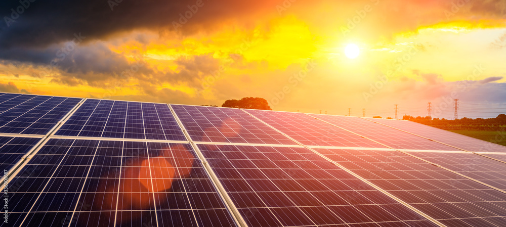 Photovoltaic solar panels and high voltage power lines at sunset sky background,green clean alternative energy. - obrazy, fototapety, plakaty 