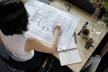 Young businesswoman architecture freelance looking at the blueprint working from home lifestyle in modern home office, Quarantine isolation during the Coronavirus (COVID-19) health crisis