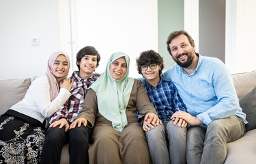 Happy Muslim family portrait on sofa