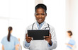 © Syda Productions - medicine, technology and healthcare concept - happy smiling african american female doctor or in white coat with tablet pc computer and stethoscope over hospital staff on background