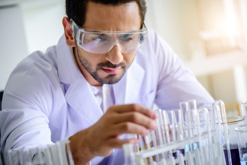 Wall Mural - attractive happiness scientist man lab technician assistant analyzing sample in test tube at laborat
