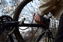 A Man Dismantles The Rear Wheel Of A Bicycle.