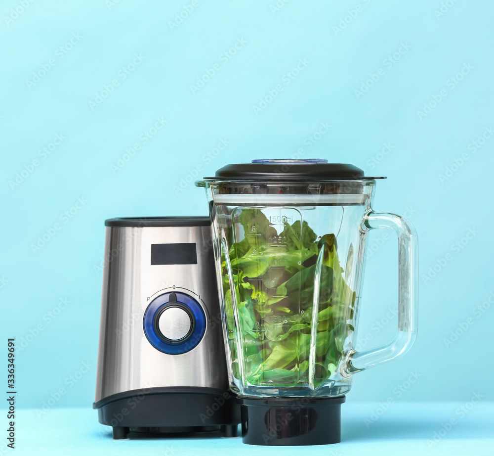 Blender with ingredients for healthy smoothie on color background