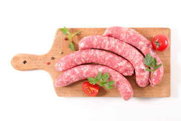 Poster - raw sausage on wooden board isolated on white background