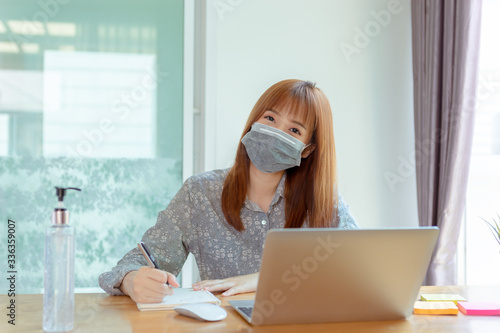 Asian woman wearing mask working from home online education , Prevent the spread of coronavirus quarantine for covid-19, Self isolation from society to reduce risks.