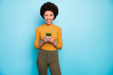 photo of funny pretty dark skin wavy lady hold telephone hands popular influencer winking eye playfu