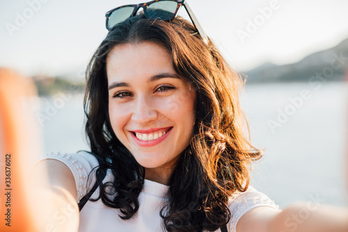 Mata magnetyczna Szczęśliwa piękna młoda kobieta robi selfie morzem w lecie