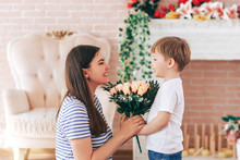The Boy Gives Beautiful Bouquet Of Flowers To His Mother, Mother S Day, March 8, Spring Time, Son Love For Mother