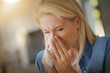 © goodluz - Middle-aged woman with allergy blowing her nose