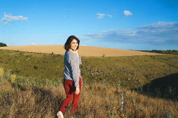 Wall Mural - smiling woman walking away in field