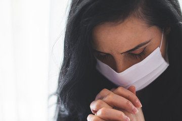 Portrait of woman with surgical mask praying