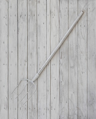 Sticker - old white pitchfork on a white wooden background