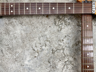 Two Rosewood guitar neck on old grey concrete. Background and wallpaper.