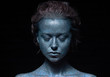 © Наталья Бирюкова - girl with a blue face in sparkles close-up against a black wall