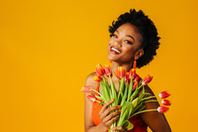 Portrait Of A Happy Smiling Young Woman With A Bouquet Of Orange Tulips And Head Tilted Back