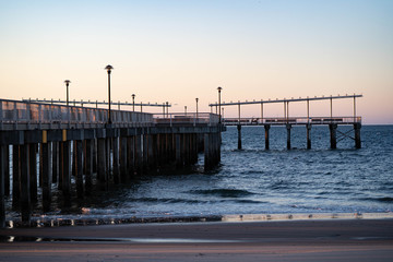 Wall Mural - Sunrise over Atlantic Ocean, blue sky, piers. Pier and blue Atlantic Ocean. 