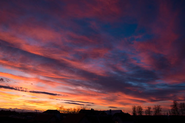 Sunset. Evening sky, clouds are painted in different bright colors: blue, red, orange, purple, pink, yellow.