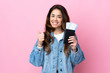 © luismolinero - Woman over isolated blue background in vacation holding a passport and plane with thumb up