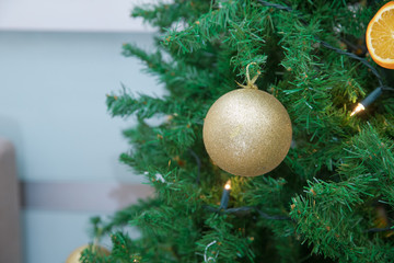 New Year. One gold ball, fir-tree toy on the Christmas tree. on a light background. Christmas card. Christmas.