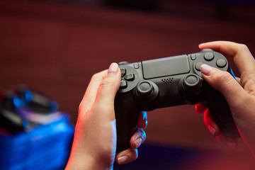 Wall Mural - Gamer holding Gamepad, Controller or Videogame Joystick Console in hands. Close up, game concept