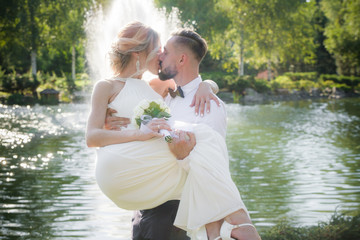 Wall Mural - The groom holds the bride in his arms at the wedding, happy newlyweds