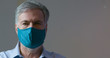 A mature man wearing a homemade face mask to help stop the spread of the coronavirus COVID19 during the world wide pandemic.