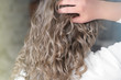 © Yulia Panova - teenage girl with natural wavy hair. blond girl touching her hair, back view. natural curly no brush method for beautiful stylish look.