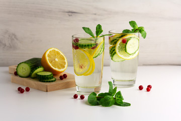 Sassy diet water. Cucumber, lemon, mint lemonade in glasses on light background