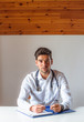 © GENETTICA - Front view of young doctor with stethoscope talking to the camera