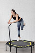 Relaxed woman jumping on trampoline.young fitness girl trains on a mini trampoline in the Studio
