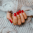 Kobieca ręka z pomalowanymi na czerwono paznokciami