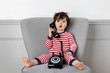 © Lisa Tichané - Young child holding vintage phone with funny surprised expression
