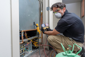 HVAC repairman charging ac unit