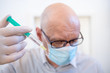 © Uwe - Leipzig, Germany, 07-04-2020 a doctor with an injection syringe and a face mask