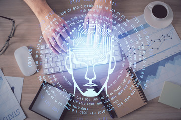 Double exposure of man's hands typing over computer keyboard and brain hologram drawing. Top view. Ai and data technology concept.