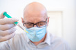 © Uwe - Leipzig, Germany, 07-04-2020 a doctor with an injection syringe and a face mask