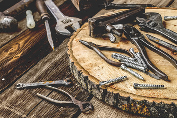 A set of metal tools in the workshop on an old rustic wooden background.concept.Father's day or labor day holiday.A greeting card or banner for your store or website.