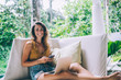 © BullRun - Cheerful woman messaging on phone and looking at camera