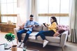 © BullRun - Couple of freelancers using devices on coach at home