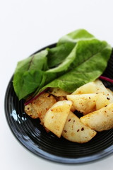 Wall Mural - Potato and anchovy stir fried served with baby leaves