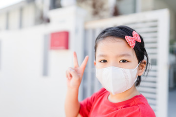 Wall Mural - Covid-19 coronavirus pandemic concept.Little chinese girl wearing mask for protect virus and OK finger hands gesture for stop covid19 virus outbreak.Stay strong at home coronavirus virus symptoms.