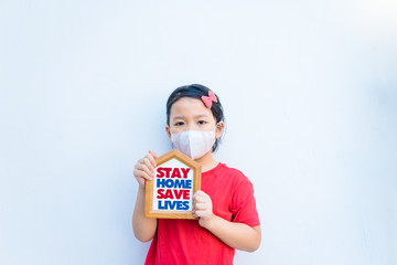 Wall Mural - Stay home save lives.Covid-19 Coronavirus.Stay Learning from home, Social distancing.Happy little asian girl showing home sign.Stay home save lives.Lockdown and Quarantined for control infection.