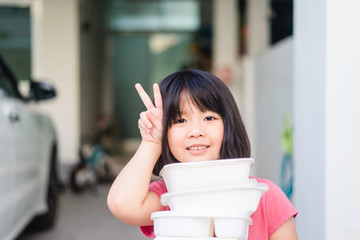 Wall Mural - Delivery service,Takeaway, Food delivery and Stay at home safe lives from Covid19 Coronavirus.Little asian girl holding go box food with hungry.Delivering Food In City.Delivery food service from home.