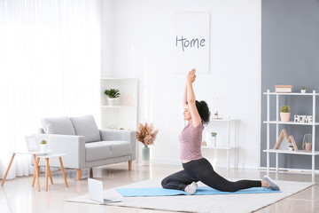 Sporty young woman training at home