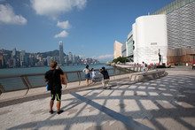 People Taking A Walk On The Hong Kong Harbour Promenade 