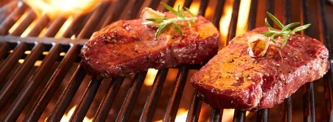 Wall Mural - Panorama banner with raw beef steak on a BBQ grill